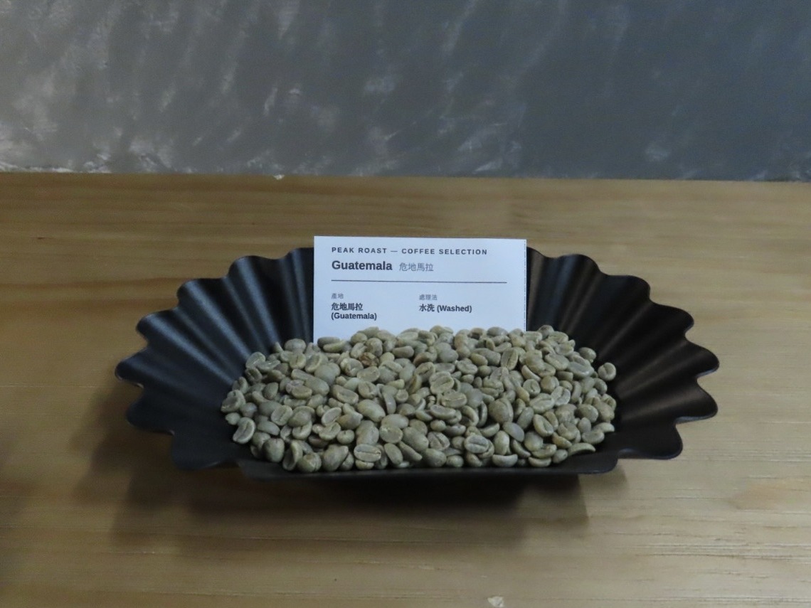 Guatemala Washed — green coffee on a black fluted tray