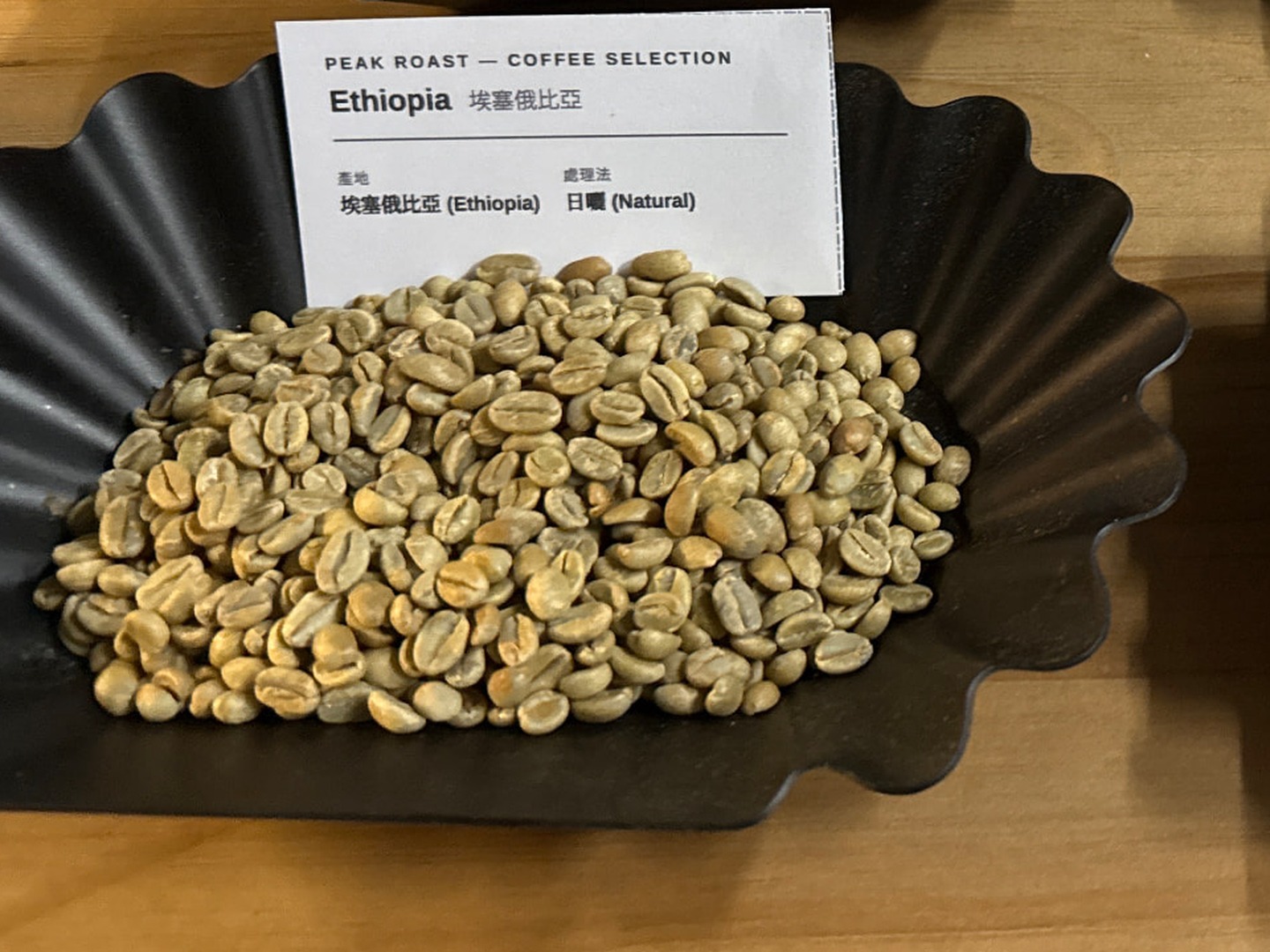 Ethiopia Natural — green coffee on a black fluted tray